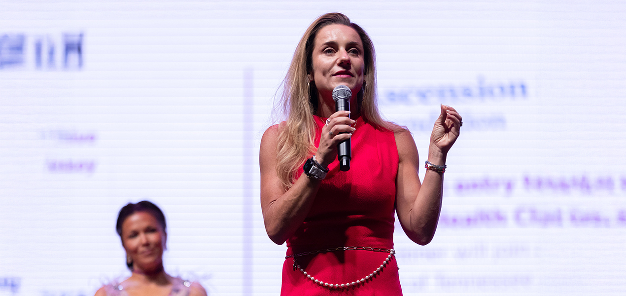 Mary Byerly standing on stage presenting.