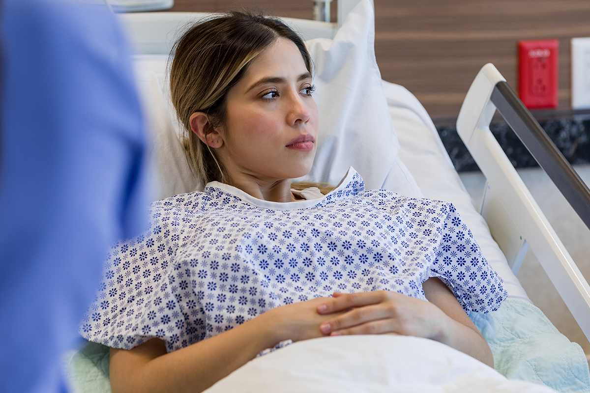Patient sitting on hospital bed.
