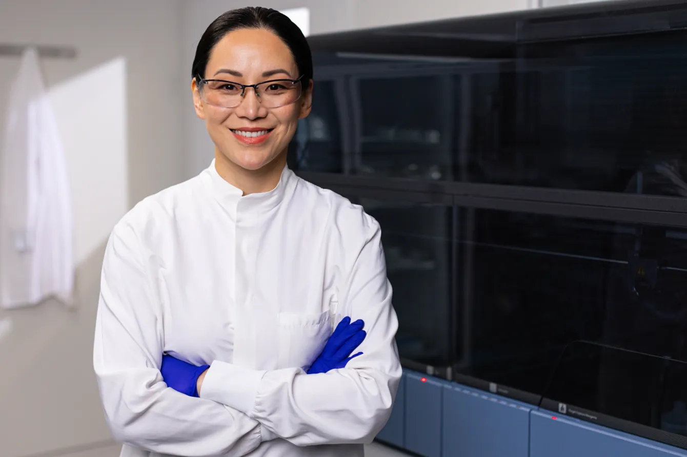 Lab technician standing in front of the Panther Fusion machine