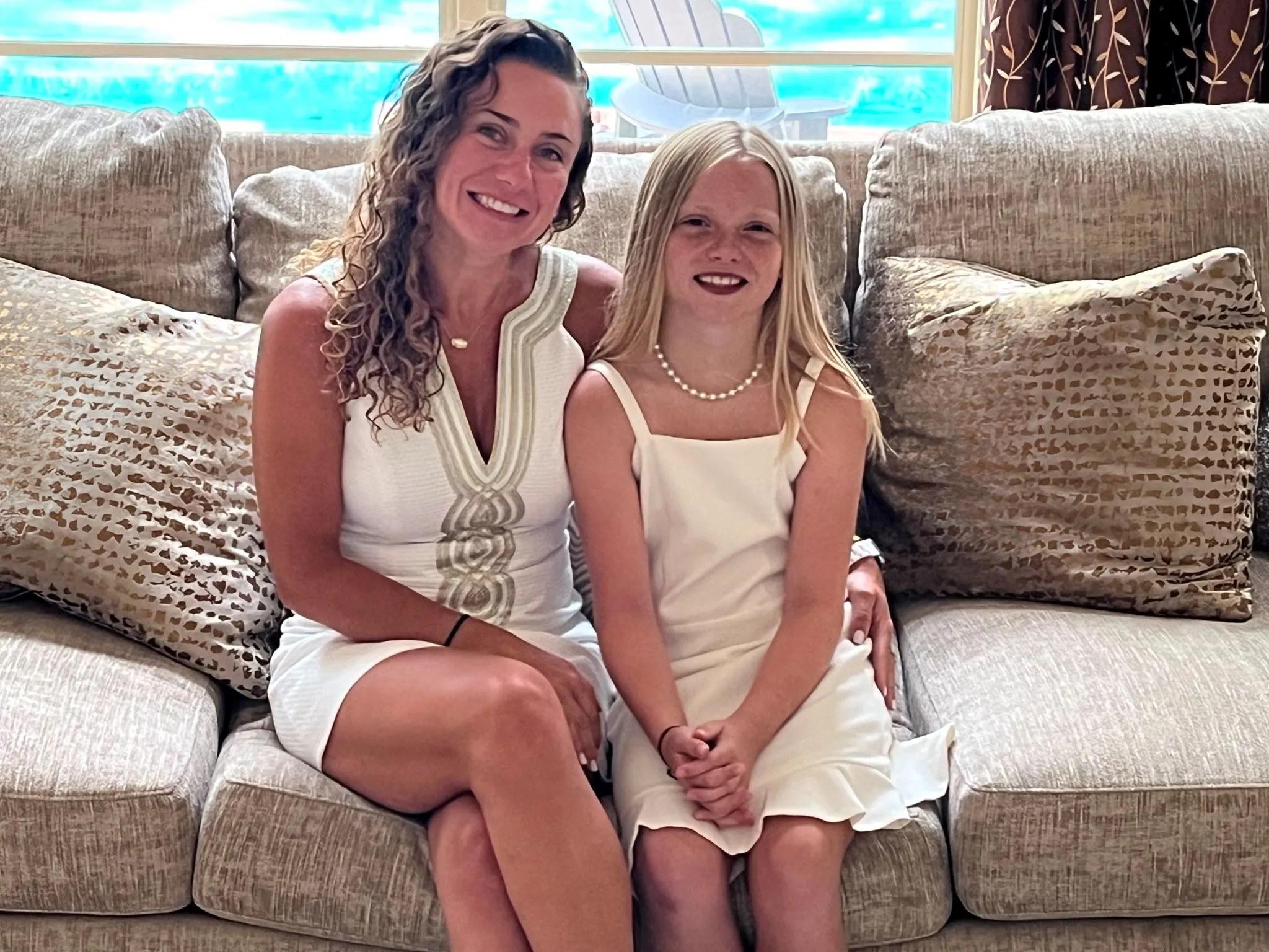 Mother and daughter sitting together on a couch