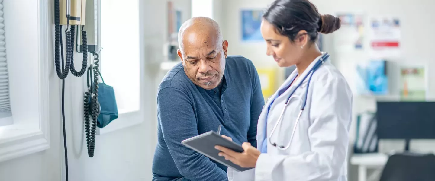 Doctor speaking to patient in exam room setting.