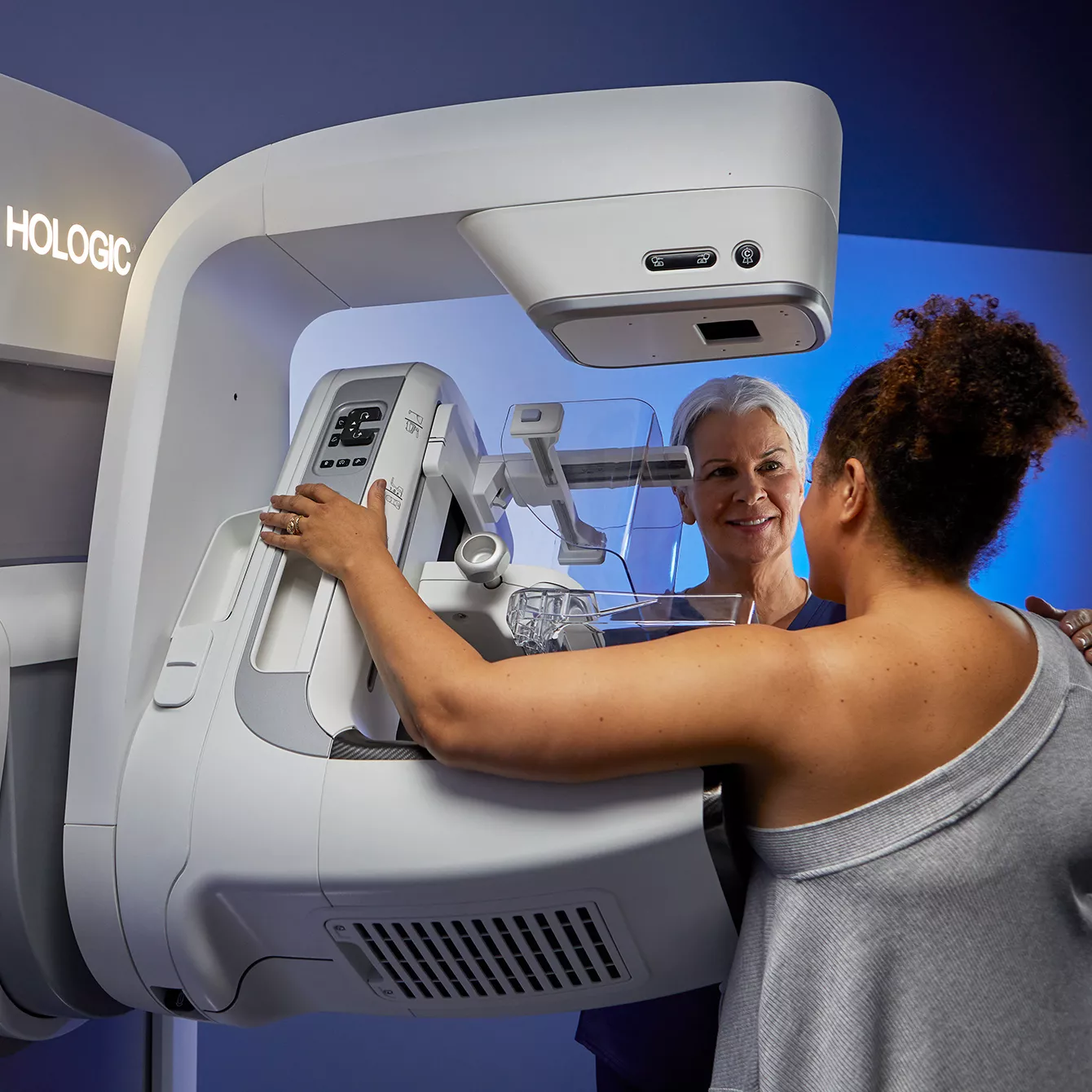 Technician administering a mammogram test to a patient using the Envision Mammography System